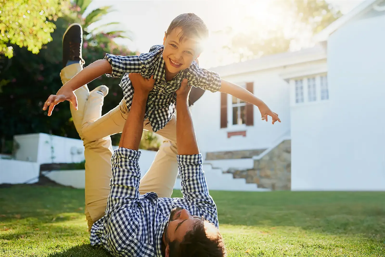 father-holding-son-on-lawn
